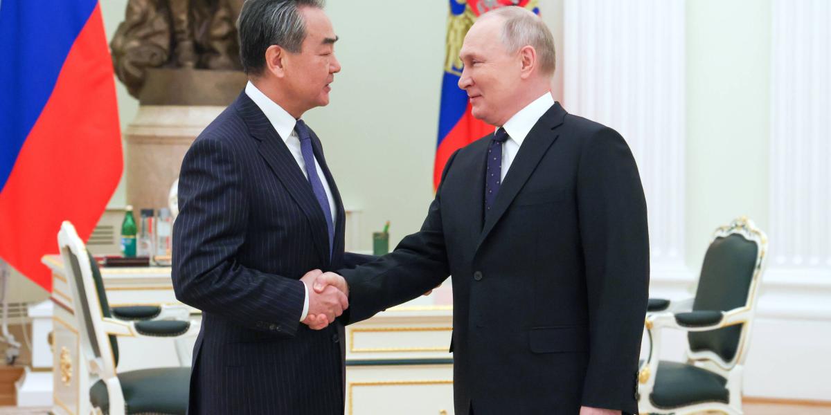Vladimir Putin y Wang Yi in, jefe de política exterior de China.