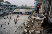 Palestinos revisan una escuela de la ONU que fue alcanzada durante un bombardeo israelí en Nuseirat.