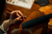 Ayoung An trabaja meticulosamente con herramientas y sustancias para hacer que un violín luzca más antiguo.