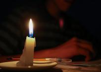 Un estudiante lee un texto a la luz de una vela en Quito (Ecuador).