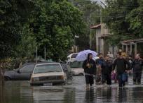 Residentes caminan por una calle inundada en el barrio de Harmonia en la ciudad de Canoas, estado de Rio Grande do Sul.