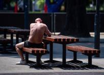 Un hombre toma el sol en un banco del centro de Budapest, en Hungría.