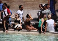 Transeúntes en Italia soportan la ola de calor.