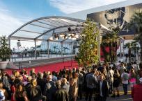 Great Auditorium of the exit door at Cannes in France, the famous red carpeted stairs and crowd of people waiting at the gate output.