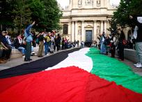 Manifestantes propalestinos junto a una enorme bandera palestina en la Universidad de la Sorbona, en Francia.