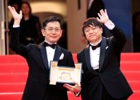 El vicepresidente de eventos y exposiciones del Studio Ghibli, Kenichi Yoda, saluda junto al director japonés y director de desarrollo creativo del parque Ghibli, Goro Miyazaki, durante la ceremonia de entrega de la Palma dor honorífica en la 77 edición del Festival de Cine de Cannes, en Cannes, sur de Francia, el 20 de mayo de 2024. (Foto de Valery HACHE / AFP)