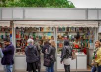 People Standing in front of a Book Shop Hoping to Find Goog Literature while Strolling on the Opening Day of the Book Fair in a Park