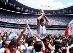 Un momento icónico de la carrera de Maradona: cargado a hombros tras la final de la Copa del Mundo en el Azteca en 1986. En medio de un tumulto de fanáticos, periodistas y fotógrafos, se puede ver cómo los espectadores y los hinchas tiran su camiseta y hacen todo lo posible por tocarlo; todo el mundo quiere un pedazo de Diego.