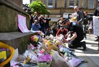 Los agentes de policía colocaron homenajes florales en la Plaza de Santa Ana, en Manchester, al noroeste de Inglaterra, establecidos como una señal de respeto a los muertos y heridos tras un ataque terrorista.