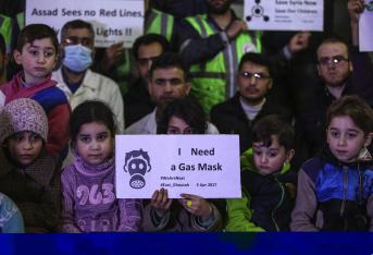 Niños sirios, junto con voluntarios y personal de servicios de primeros auxilios muestran pancartas e imágenes de las víctimas del supuesto ataque químico que se produjo el pasado martes en la localidad siria de Jan Shijún, durante una concentración para mostrar solidaridad con los fallecidos, en Douma (Siria) ayer, 5 de abril de 2017. EFE/Mohammed Badra