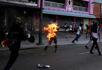 Un hombre que fue incendiado por personas que lo acusaron de robar durante una manifestación contra el presidente de Venezuela, Nicolás Maduro, se presenta entre los partidarios de la oposición en Caracas, Venezuela, el 20 de mayo de 2017.