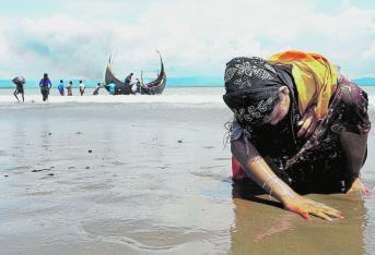 El drama de los refugiados Rohinyás. Una refugiada de esta etnia musulmana toca la orilla después de cruzar de Birmania a Bangladés, por la bahía de Bengala, debido a la ola de violencia en el primer país.