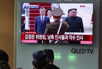 Surcoreanos observan la transmisión por televisión del líder norcoreano, Kim Jong-un, y su esposa, Ri Sol-ju, dando la bienvenida al presidente surcoreano, Moon Jae-in, y su esposa, Kim Jung-sook, en el Aeropuerto Internacional Sunan, en Pyongyang (Corea del Norte), en una estación de tren en Seúl (Corea del Sur) hoy, martes 18 de septiembre de 2018.