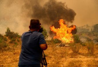 Un camarógrafo filma durante un incendio forestal masivo que envolvió una región turística mediterránea en la costa sur de Turquía cerca de la ciudad de Manavgat, el 29 de julio de 2021.