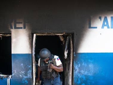 Un policía sale este martes de la comisaría de Carrefour Aéroport, que fue incendiada la noche de ayer por miembros de pandillas, en Puerto Príncipe (Haití).