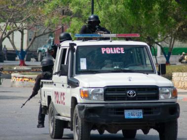 Oficiales de policía armados monitorean el área después de la violencia de pandillas en el vecindario la noche del 21 de marzo de 2024, en Puerto Príncipe.