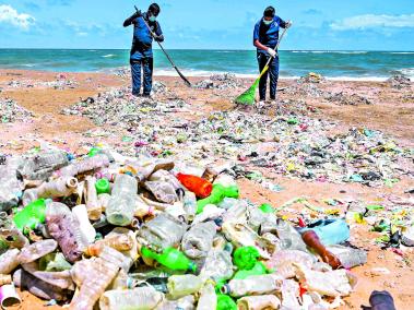 Policía ambiental intenta limpiar basuras en Mount Lavinia, Colombo, Sri-Lanka.