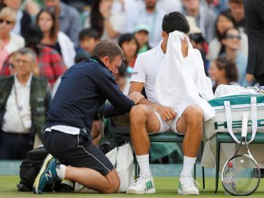 Novak Djokovic ea atendido por el fisioterapeuta.