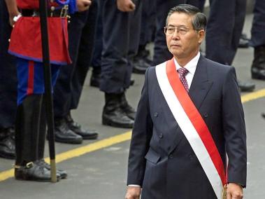 El presidente peruano, Alberto Fujimori, usa una banda de honor mientras camina hacia una catedral para participar en un servicio en honor del día de la independencia del país, el julio del año 2000.