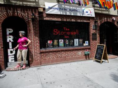 Una mujer posa junto a la palabra "Pride" (Orgullo) en la fachada del famoso Stonewall Inn, un bar situado en los números 51 y 53 de la calle Christoper, en el barrio de Greenwich Village en Nueva York (Estados Unidos).