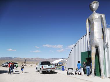 Varias personas caminan cerca de la llamada Área 51 en el desierto de Nevada frente al centro de investigaciones alienígenas.