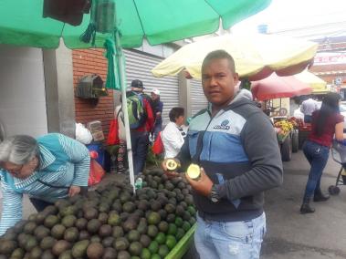 Giomer Farías luce los aguacates que le dan el dinero para sus necesidades básicas y para ahorrar el dinero que envía a su familia en Venezuela..
