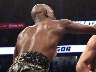 Mayweather asesta un golpe a McGregor durante la publicitada pelea que se celebró en Las Vegas.