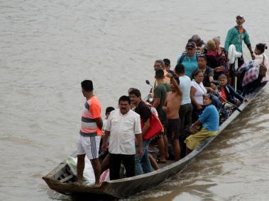 Migrantes venezolanos cruzan en botes desde La Victoria, en Venezuela, hasta Arauquita, en Colombia.