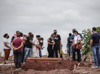 Familiares lloran la muerte por covid-19 de un ser querido, durante su entierro en Río de Janeiro (Brasil).