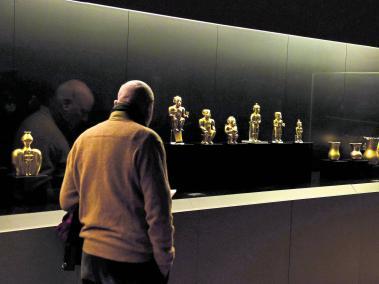 Un hombre observa una parte de las 122 piezas de la colección Quimbaya, que exhibe el Museo América en Madrid. Los objetos fueron donados en 1892 por el Gobierno colombiano a España.