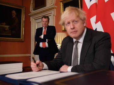 En esta foto de archivo tomada el 30 de diciembre de 2020, el negociador comercial principal del Reino Unido, David Frost (izq.), observa cómo el primer ministro británico, Boris Johnson, firma el Acuerdo de Comercio y Cooperación entre el Reino Unido y la UE.