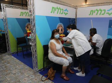 Un mujer Israelí recibe tercera dosis de vacuna contra el covid-19 en Jerusalén