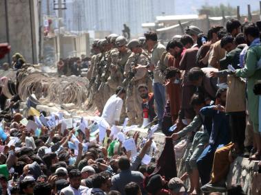 Los afganos luchando por llegar a las fuerzas extranjeras para huir del país fuera del aeropuerto en Kabul, el 26 de agosto de 2021, horas antes del doble atentado suicida.