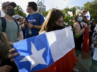 Una mujer sostiene una bandera de Chile durante el cierre de la campaña presidencial.