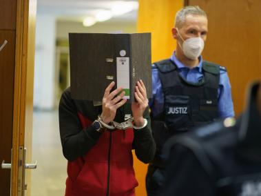 El acusado iraquí Taha Al-J. cubriéndose el rostro con una carpeta, en el Tribunal Regional Superior de Frankfurt en Frankfurt am Main, Alemania, el 30 de noviembre de 2021.