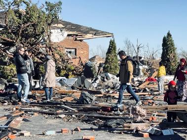 Ciudadanos se reúnen en medio de los escombros que dejó el tornado en Kentucky.