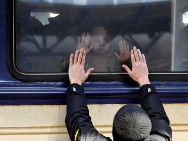 Un hombre coloca sus manos frente a la ventana del tren mientras que se despide de su hija, en la estación central de trenes de Kiev. Ucrania acusó al Kremlin de "terror nuclear" después de que la planta de energía atómica más grande de Europa fuera atacada y tomada por fuerzas invasoras.