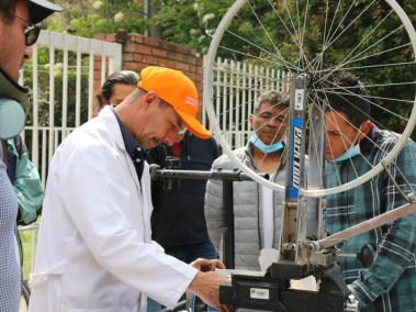 Un instructor da una clase de mecánica de bicicletas de gama baja. Sus alumnos pertenecen a la Comunidad de Vida el Camino, en Bogotá.