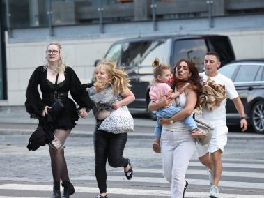 Ciudadanos daneses corren tras reportarse un tiroteo en un centro comercial de Copenhague.