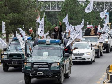 combatientes talibanes sostienen armas mientras viajan en convoy para celebrar el día de su victoria, en Kabul.