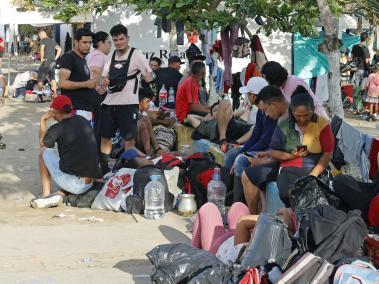 Migrantes esperan para abordar una lancha hacia la frontera con Panamá.
