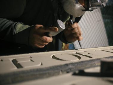 NYT: Trabajadores tallan letras en un panel de piedra que se convirtió en parte de la nueva Puerta de los Exonerados.