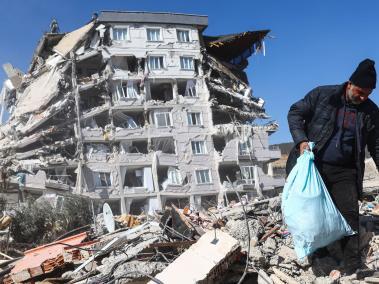 Hombre intenta rescatar algunas pertenencias de entre los escombros tras el sismo en Turquía.