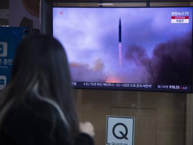 Una mujer sigue el lanzamiento de un misil de corto alcance norcoreano en una televisión instalada en una estación de Seúl, Corea del Sur