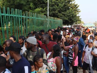 Migrantes hacen fila para conseguir documentación para transitar por el país.