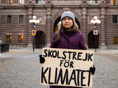 Una foto de archivo tomada el 19 de noviembre de 2021 muestra a la activista climática sueca Greta Thunberg mientras posa para una foto con un cartel que dice "Huelga escolar por el clima" mientras protesta frente al Parlamento sueco (Riksdagen) en Estocolmo.