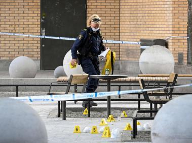 Un oficial forense de la policía trabaja en la escena de un tiroteo en el centro comercial Farsta, en el sur de Estocolmo.