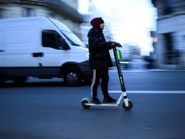 Hombre monta patineta eléctrica en las calles de París.