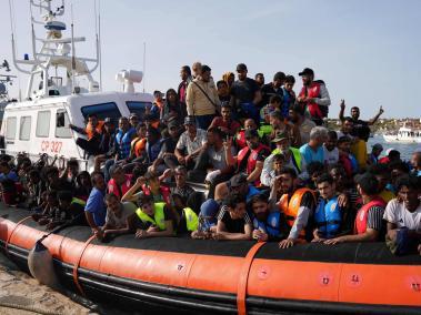 Migrantes llegan en pequeñas embarcaciones al puerto de Lampedusa, en Italia.