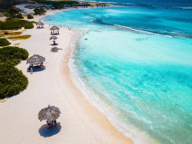 Aruba recibe de 45 a 50 vuelos diarios. Sus playas de océanos azules y ambiente tropical, como Baby Beach (foto), son un imán para el turismo.